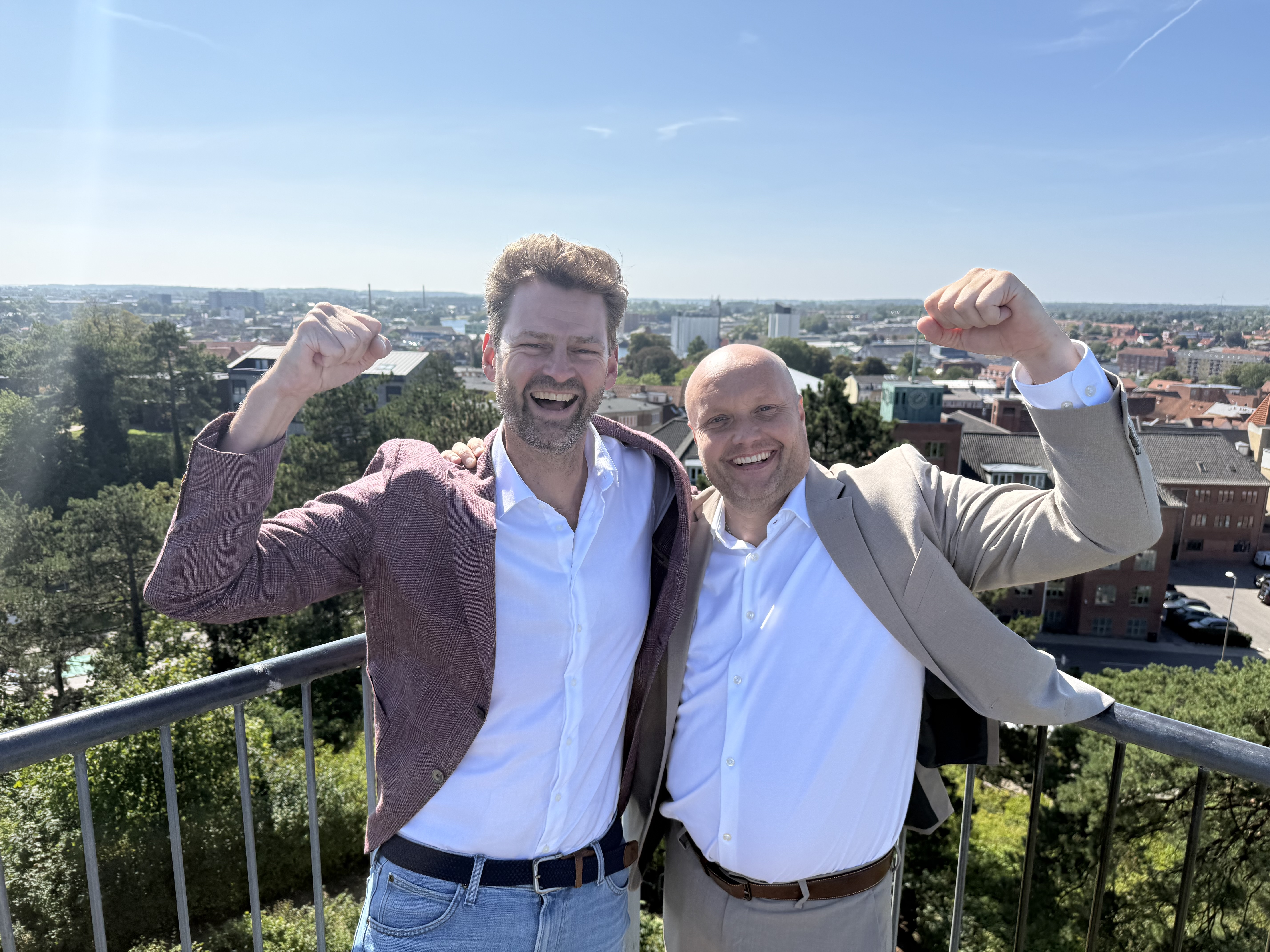 Direktør Rasmus Holst-Sørensen, Næstved Erhverv, og borgmester Kenneth Sørensen har armene over hovedet over årets placering i DI's undersøgelse af Lokal Erhvervsvenlighed. Foto: Næstved Kommune